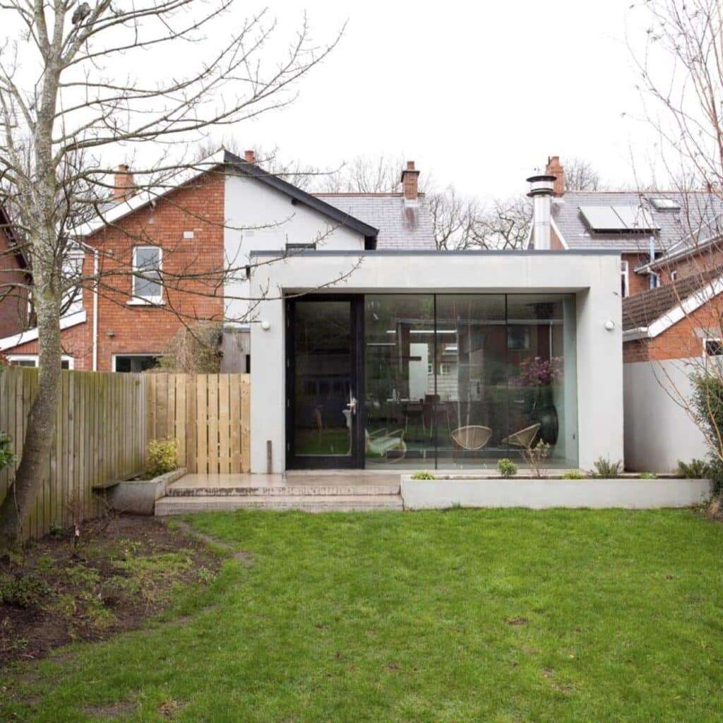 A mid century house with a modern extension as seen from the rear garden