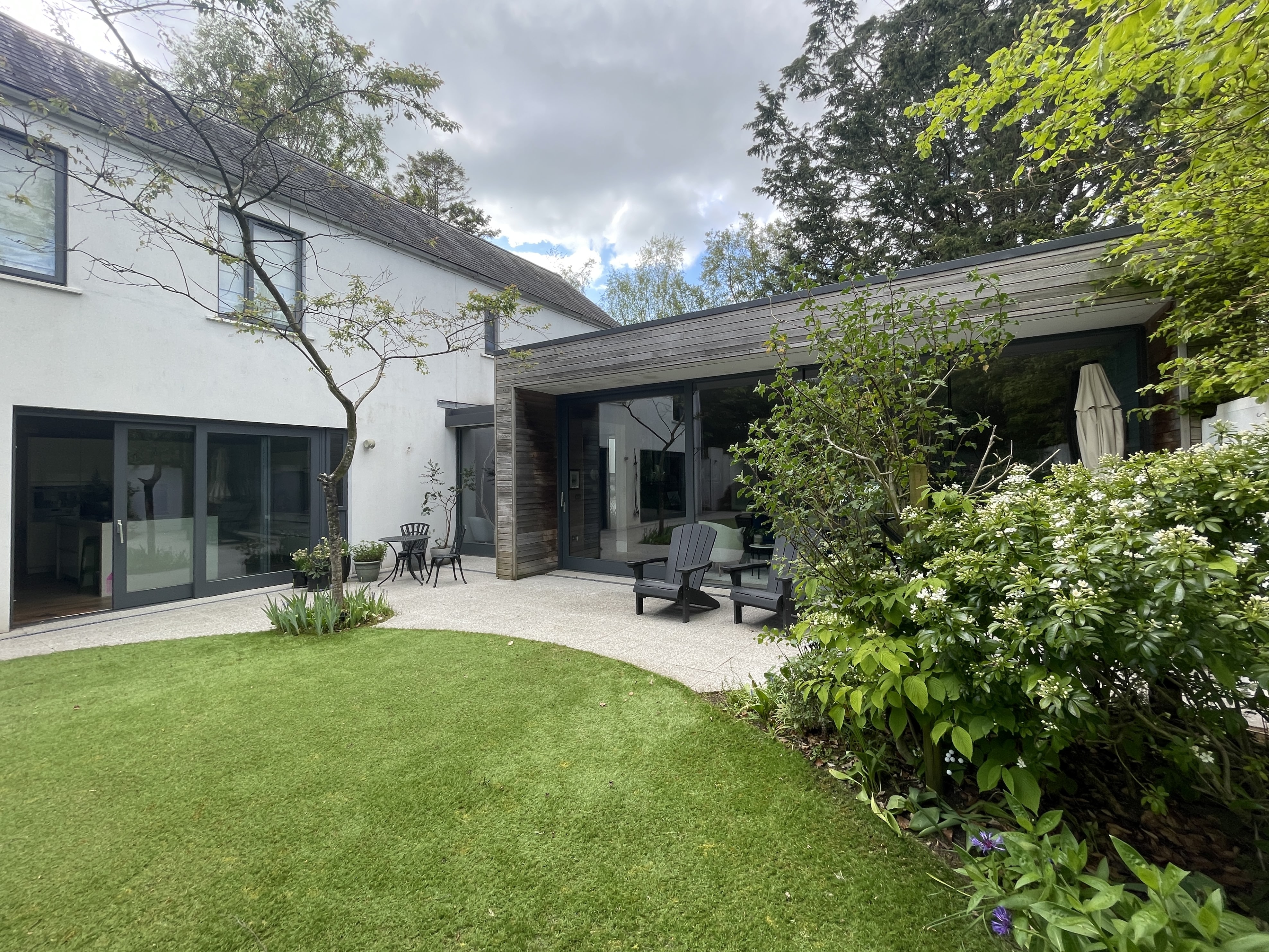Single storey cedar clad living room looking onto courtyard garden in Hillsborough Co Down